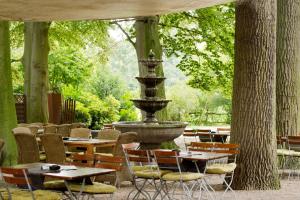 a fountain in a patio with tables and chairs at Boutique Hotel Kauers in Verl