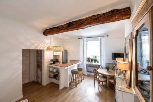 a kitchen and living room with a table and chairs at Le Pigeonnier in Saint-Tropez