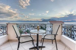 a table on a balcony with a view of the ocean at Niovi Luxury Apartments in Loutra Edipsou