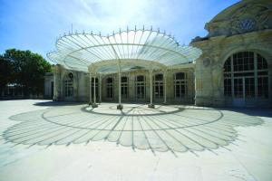 a large building with a clock on it at Résidence les Dômes par Vy Resort Thermal & Spa in Vichy