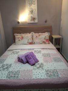 イラクリトサにあるSweet Home Nea Iraklitsaのベッド1台(布団、紫のタオル2枚付)