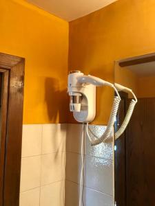 łazienka z suszarką do włosów na żółtej ścianie w obiekcie Borgo Vecchio w mieście Carbognano