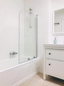 une salle de bain blanche avec une douche et un lavabo dans l'établissement Muy luminoso en San Mamés, à Bilbao