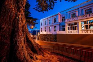 a building with a tree in front of it at The Burlington Luxury Octagon Apartment in Dunedin