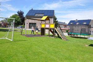 una familia jugando en un patio de juegos con un objetivo en Gîtes de Chevémont, en Plombières