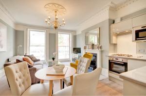 a kitchen and living room with a table and chairs at Stunning Montpellier Spa Road apartment in Cheltenham