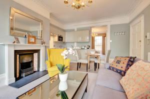 a living room with a couch and a fireplace at Stunning Montpellier Spa Road apartment in Cheltenham