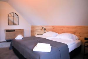 a bedroom with a large bed with two towels on it at Apartamenty Skarpa in Mysłakowice