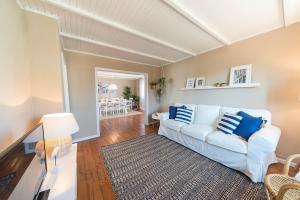 sala de estar con sofá blanco y almohadas azules en Beachliving Esmoriz, en Esmoriz