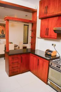 a kitchen with wooden cabinets and a counter top at Unique Towers Luxury Boutique Suites in Colombo