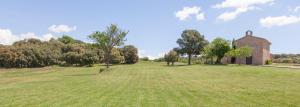 an open field with a church in the distance at El Porxo de Mateus in Sagás