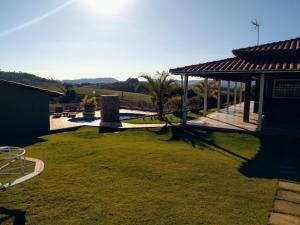 een tuin met een grasveld met een paviljoen bij Chácara reis in Socorro