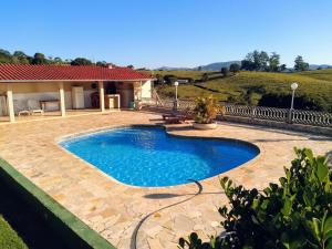 a swimming pool in front of a house at Chácara reis in Socorro