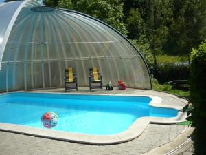 a swimming pool with two chairs and a dome at Chata Rozárka in Dolni Dvur