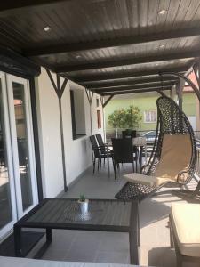 eine Terrasse mit 2 Korbstühlen und einem Tisch in der Unterkunft Korona Apartman Balatonboglár in Balatonboglár