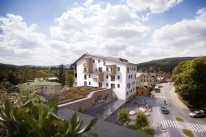 a building with a green roof on a city street at Apartmany Arber in Železná Ruda