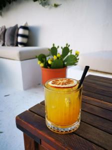 a glass of orange juice sitting on a wooden table at Hotel Akti Kavala in Paleo Tsifliki