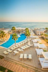 
a beach filled with lots of palm trees at Parthenis Beach, Suites by the Sea in Malia
