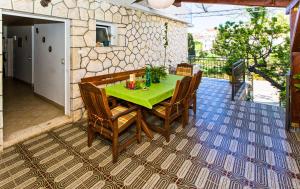 a green table and chairs on a patio at Rooms Barbarić in Hvar
