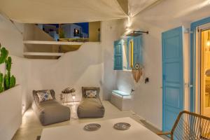 a room with two chairs and a staircase with blue doors at Mykonian Mews Luxury Suites in Psarou +37 photos