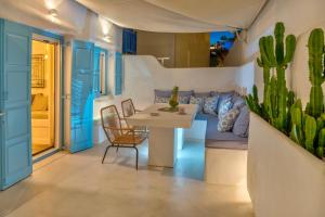 a dining room with blue doors and a table and cactus at Mykonian Mews Luxury Suites in Psarou
