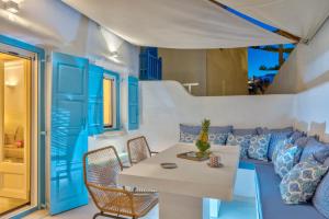 a living room with a blue couch and a table at Mykonian Mews Luxury Suites in Psarou
