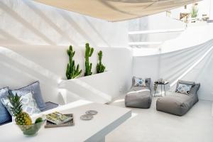 a living room with white walls and a white table at Mykonian Mews Luxury Suites in Psarou