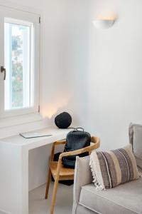 a room with a desk and a chair and a window at Mykonian Mews Luxury Suites in Psarou