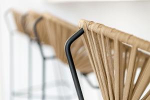 a row of wooden chairs in a row at Mykonian Mews Luxury Suites in Psarou