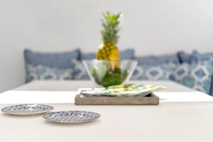 a table with four plates and a pineapple on it at Mykonian Mews Luxury Suites in Psarou