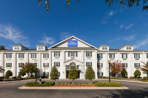Un edificio blanco con un cartel encima. en Baymont by Wyndham Henderson Oxford, en Henderson