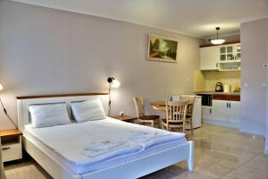 a bedroom with a bed and a table and a kitchen at Sirena Palace Family Hotel in Obzor