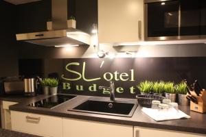 a kitchen with a sink and a sign that reads old budget at SL'otel Budget in Bernburg