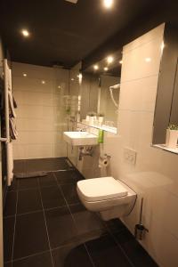 uma casa de banho com um WC, um lavatório e um espelho. em SL'otel Budget em Bernburg