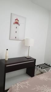 a black desk with a lamp next to a bed at Apartamento Gaivota in Sesimbra
