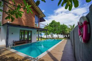 a house with a swimming pool next to a house at Solas Surf in Ahangama