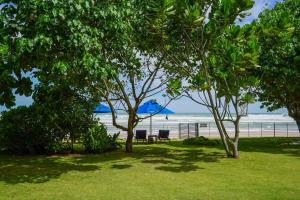 阿杭格默Solas Surf的沙滩上的两把椅子和一把蓝色遮阳伞