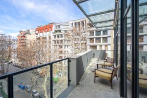 a balcony with a chair and a table and some buildings at Hotel Atlas Abashidze in Tbilisi City