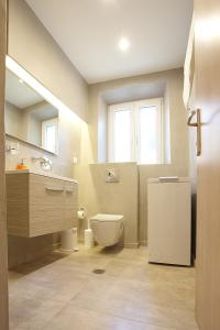 uma casa de banho com um WC, um lavatório e uma janela em Liston Inn Suites (Piazza) - Heart of Corfu Old Town em Corfu Town