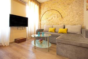 uma sala de estar com um sofá e uma mesa em Liston Inn Suites (Piazza) - Heart of Corfu Old Town em Corfu Town