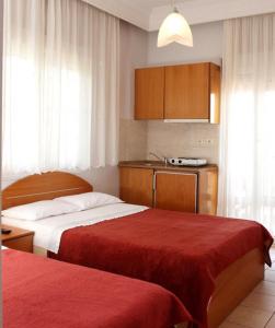 a hotel room with two beds and a kitchen at Noni Rooms in Agia Triada