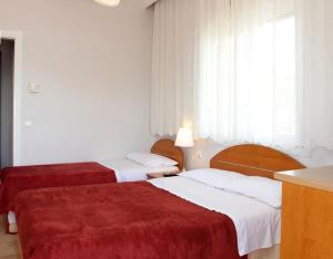 a hotel room with two beds with red sheets at Noni Rooms in Agia Triada