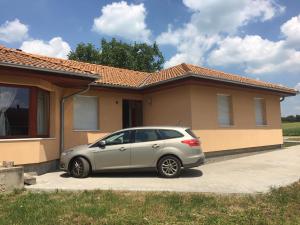 een zilveren auto geparkeerd voor een huis bij BB Szabó Villa in Balatonboglár