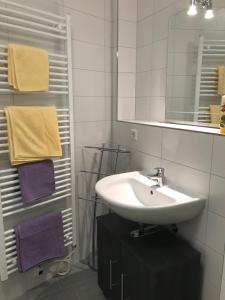 uma casa de banho com lavatório, espelho e toalhas em Lilians modern Appartement in historical Citycenter em Graz