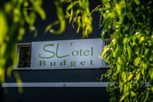 a sign for a hotel budler is seen through trees at SL'otel Budget in Bernburg