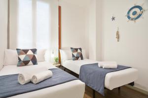 a room with two beds with towels on them at Uma Suites Barceloneta Beach in Barcelona