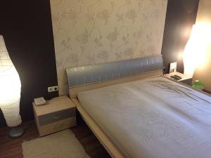 um quarto com uma cama e uma mesa de cabeceira com duas luzes em BB Szabó Villa em Balatonboglár
