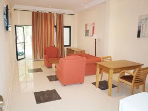 een woonkamer met een rode bank en een tafel bij Senegambia Beach Hotel in Sere Kunda NDing
