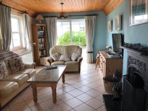 a living room with a couch and a fireplace at Cliff Cottages in Liscannor