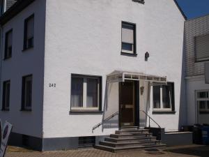 a white building with a door and stairs on it at Muttis Apartment in Mönchengladbach